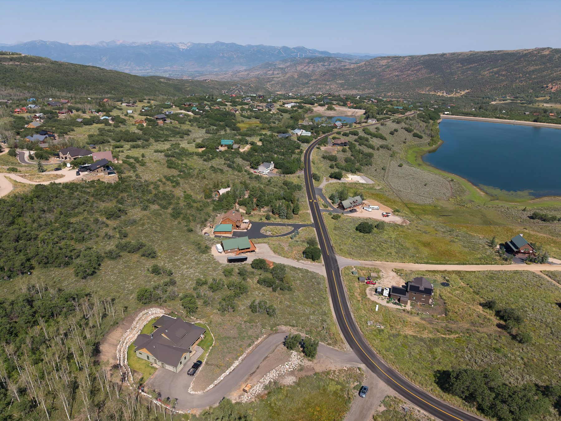 Wide aerial view of Timberlakes community with Witts Lake and mountain range backdrop near 10220 E Lake Pines Dr Heber City Utah