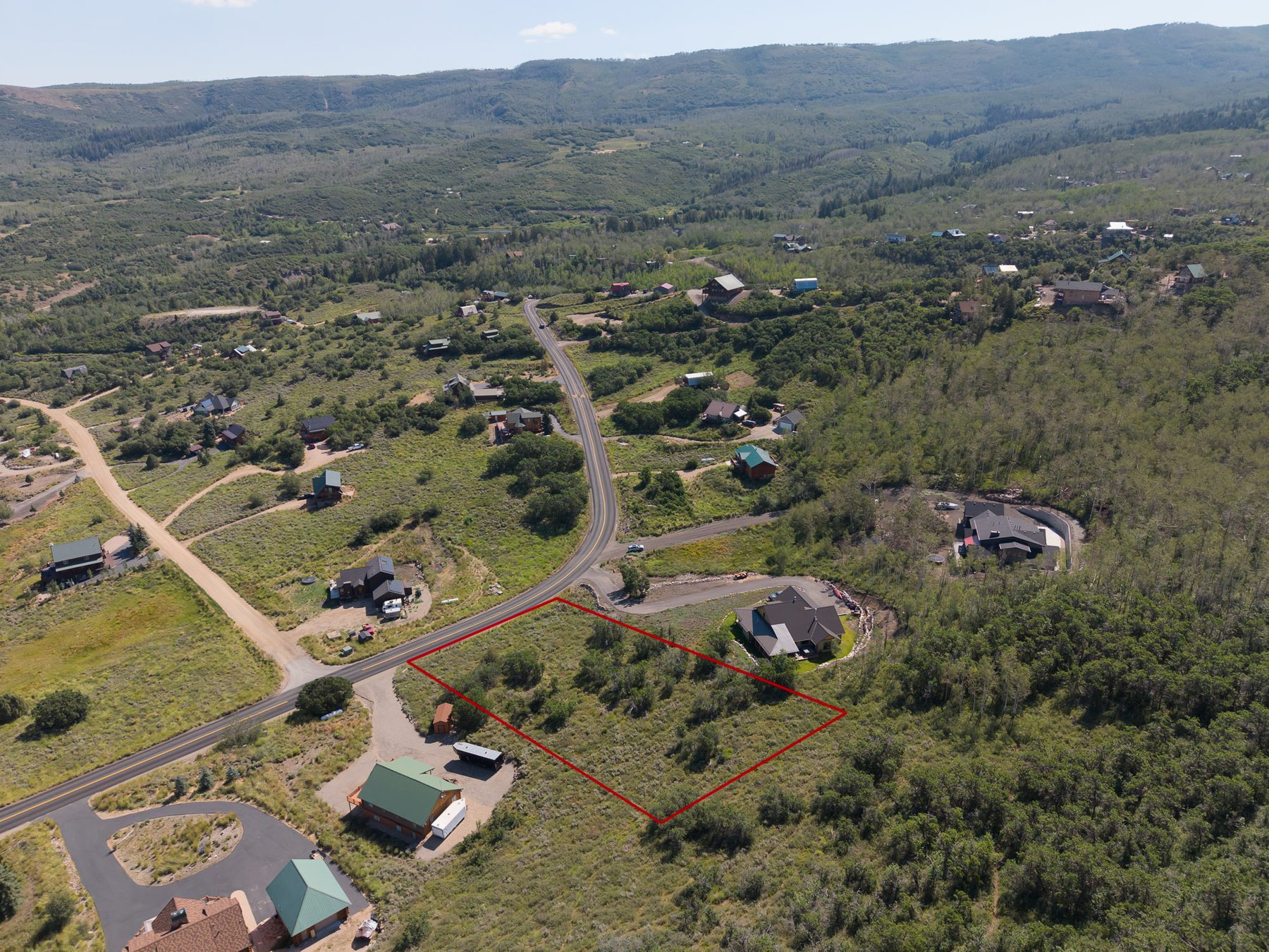 Wide aerial drone view of 10220 E Lake Pines Dr with red lot boundary lines in Timberlakes community Heber City Utah