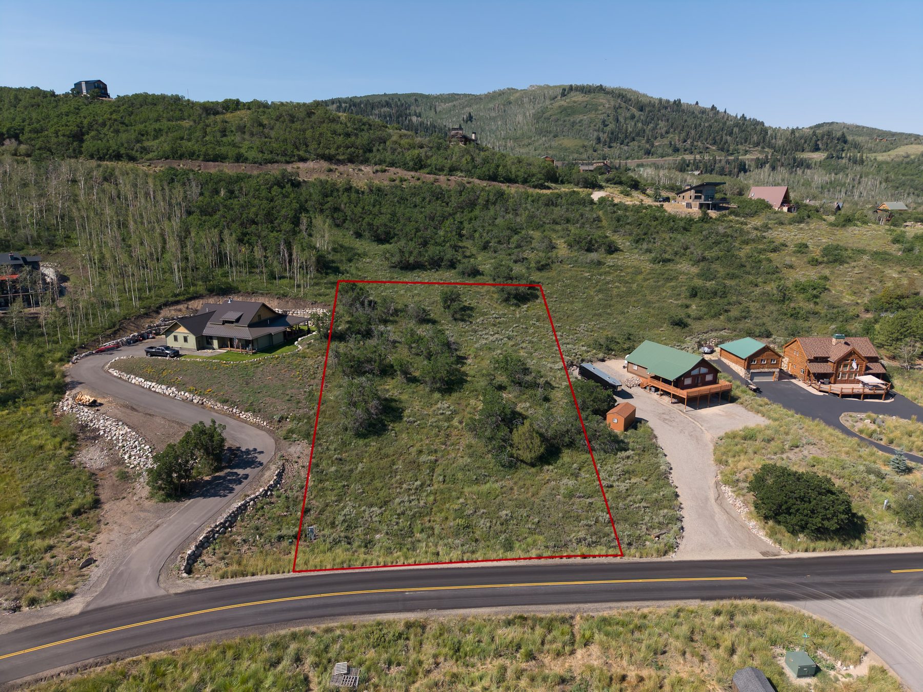 Street-level aerial view of 10220 E Lake Pines Dr lot with red boundary lines showing neighboring cabins in Timberlakes